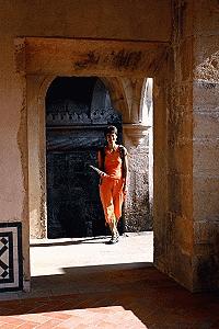 Therese is splashed with some late afternoon sun as she walks through the interior of the Convento Christo